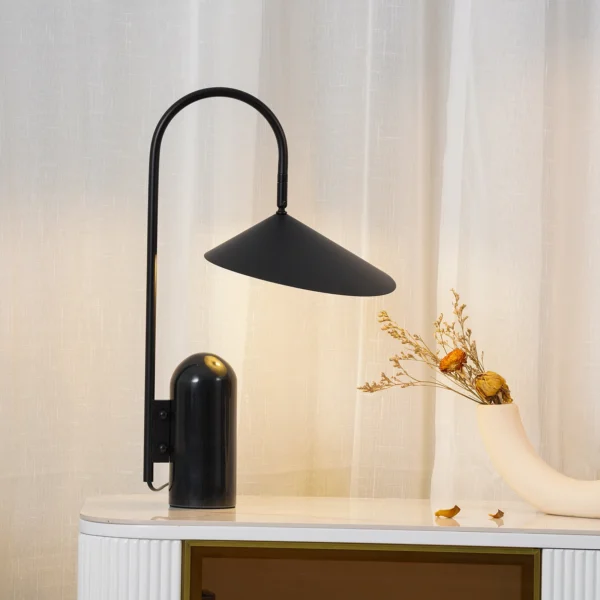 This Arum Table Lamp gives a soft and uniform light with the off-white matte present in the interior of the shade. You can adjust the lampshade to provide the perfect light setting for any occasion