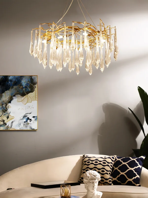 A mesmerizing statement that will inspire awe from above, the fitting features organically formed brass branches dripping with teardrop shapes of handblown glass. Crafted so that it plays with light in an enchanting manner, the chandelier would command attention in a contemporary space.