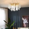 A mesmerizing statement that will inspire awe from above, the fitting features organically formed brass branches dripping with teardrop shapes of handblown glass. Crafted so that it plays with light in an enchanting manner, the chandelier would command attention in a contemporary space.