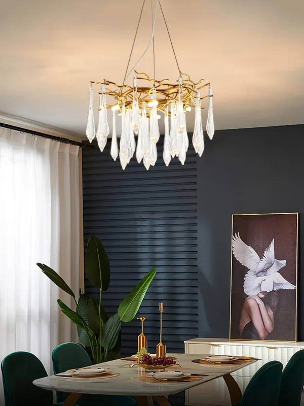 A mesmerizing statement that will inspire awe from above, the fitting features organically formed brass branches dripping with teardrop shapes of handblown glass. Crafted so that it plays with light in an enchanting manner, the chandelier would command attention in a contemporary space.