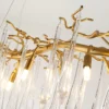 A mesmerizing statement that will inspire awe from above, the fitting features organically formed brass branches dripping with teardrop shapes of handblown glass. Crafted so that it plays with light in an enchanting manner, the chandelier would command attention in a contemporary space.