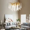 A mesmerizing statement that will inspire awe from above, the fitting features organically formed brass branches dripping with teardrop shapes of handblown glass. Crafted so that it plays with light in an enchanting manner, the chandelier would command attention in a contemporary space.