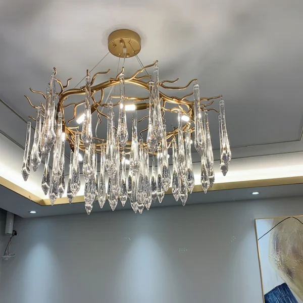 A mesmerizing statement that will inspire awe from above, the fitting features organically formed brass branches dripping with teardrop shapes of handblown glass. Crafted so that it plays with light in an enchanting manner, the chandelier would command attention in a contemporary space.