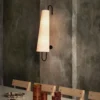 Elevate your home décor with the Anchor Wall Lamp, exclusively from Lia. This elegant wall lamp blends modern aesthetics with timeless materials, featuring a sturdy metal frame paired with a high-quality fabric shade. The unique elongated design and angled shade provide focused illumination, perfect for creating a warm, inviting atmosphere in any room. Ideal for bedrooms, living areas, or hallways, the Ancora Wall Lamp not only offers practical lighting but also adds a touch of sophistication to your interior design. Enhance your space with the refined style and quality craftsmanship of Lia’s Ancora Wall Lamp.